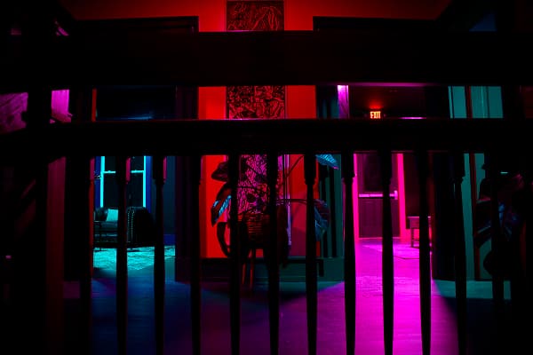 Karaoke room with pink lighting and a microphone on a stand